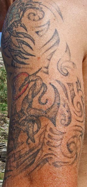 Hell imagery tattoo on man's arm